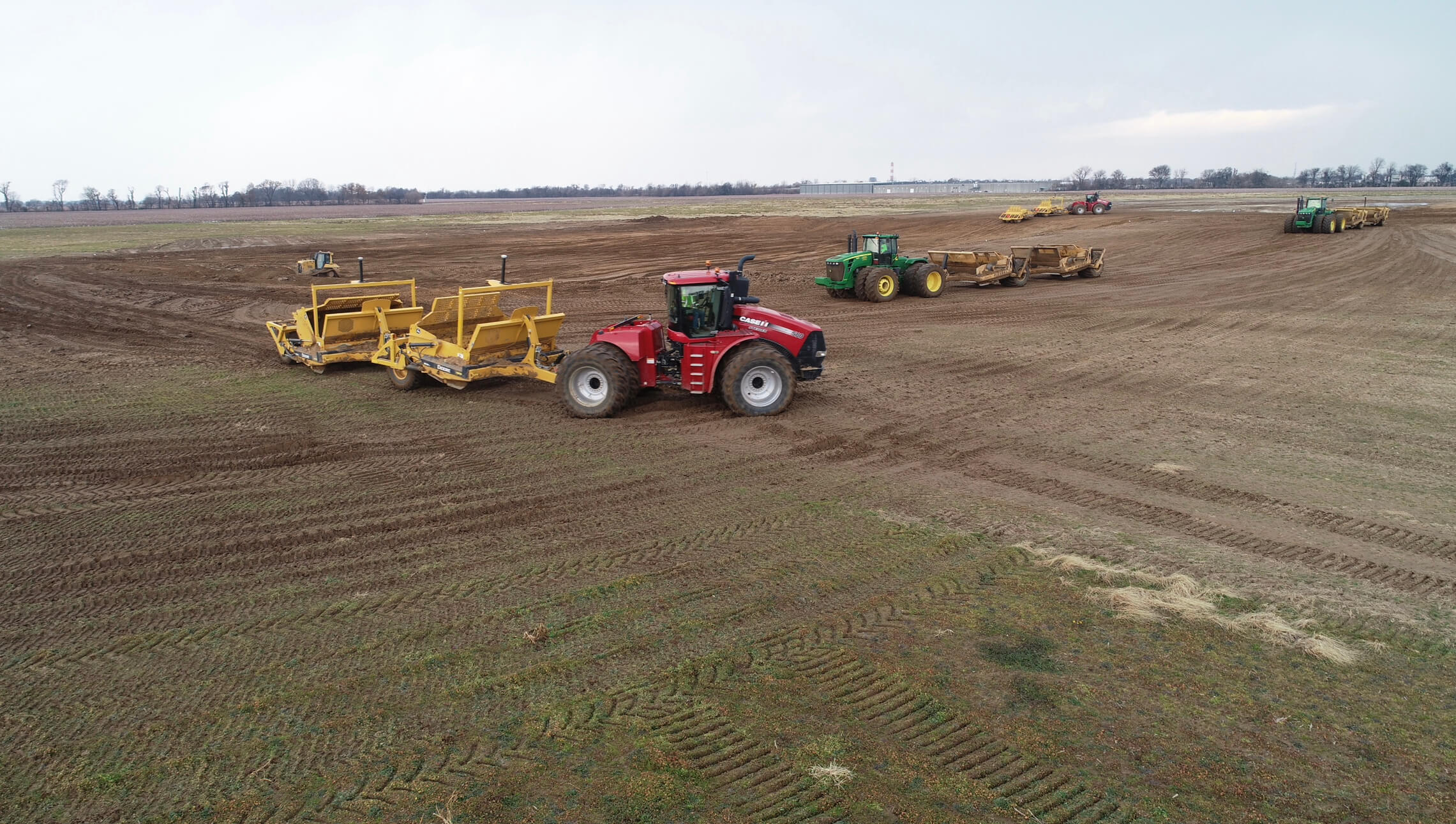 A couple of tractors that are in the dirt.