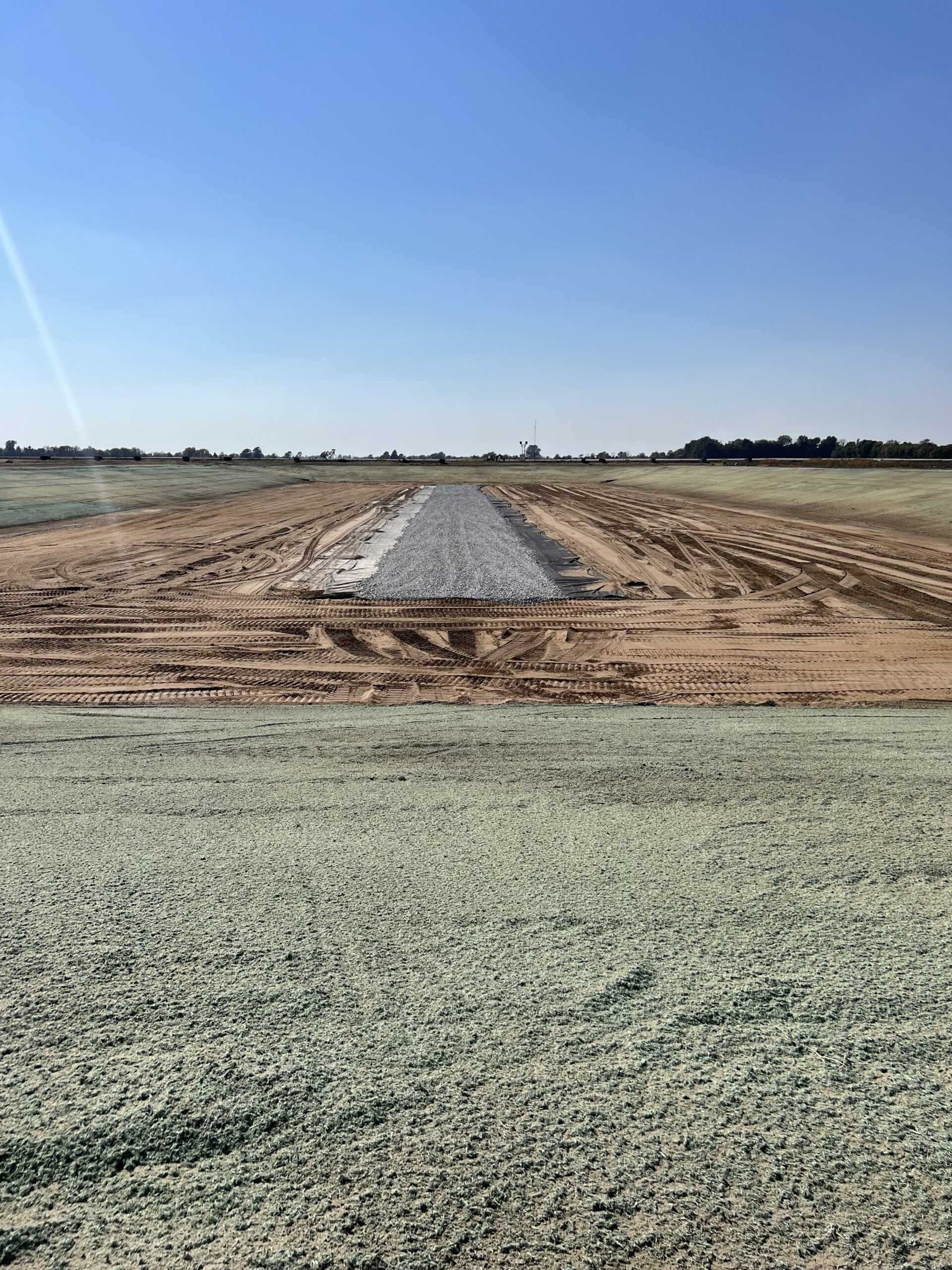 A dirt field with a road in the middle of it.