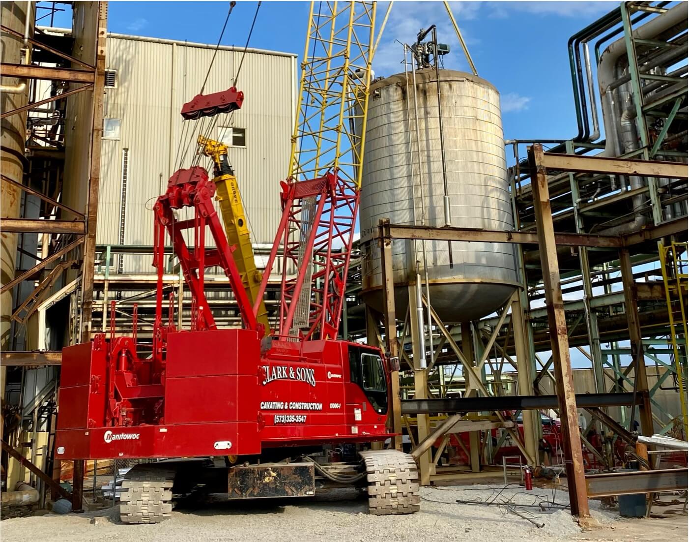 A red Clark & Sons crane parked in front of a building